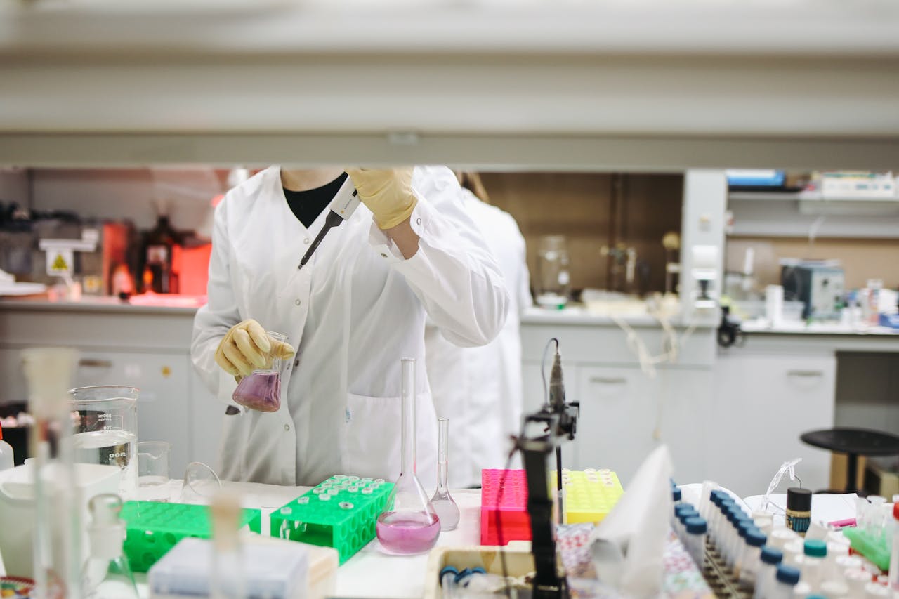 mobile-02 Scientist in a lab coat handling samples for scientific research in a modern laboratory setting.